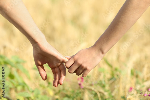 Young couple holding hands on beautiful field © Africa Studio