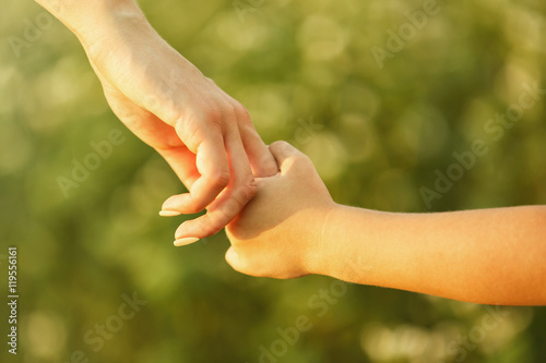 Parent and child holding hands outdoor © Africa Studio