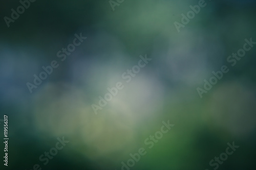 Circular bokeh green background with white, green and yellow patches of light