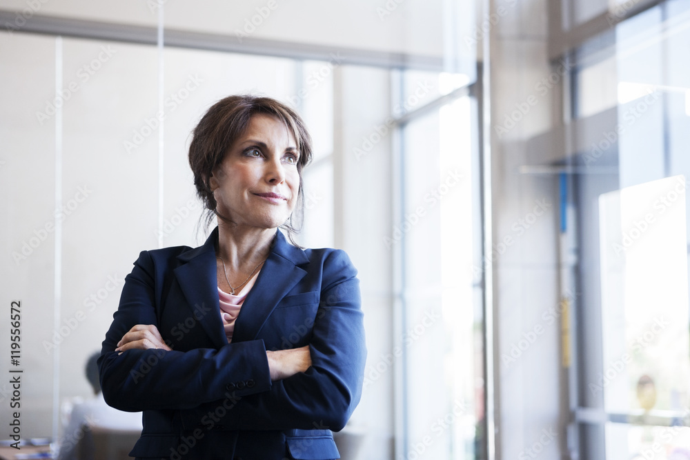 Thoughtful businesswoman standing in office Thoughtful businesswoman standing in office