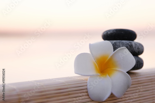 Spa stones and plumeria on sunset background