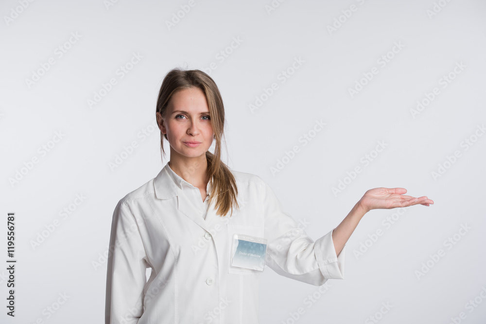 Portrait of beautiful nurse looking at camera and gesturing. Beautiful clinic assistant show to copy space Portrait of beautiful nurse looking at camera and gesturing. Beautiful clinic assistant show to copy space