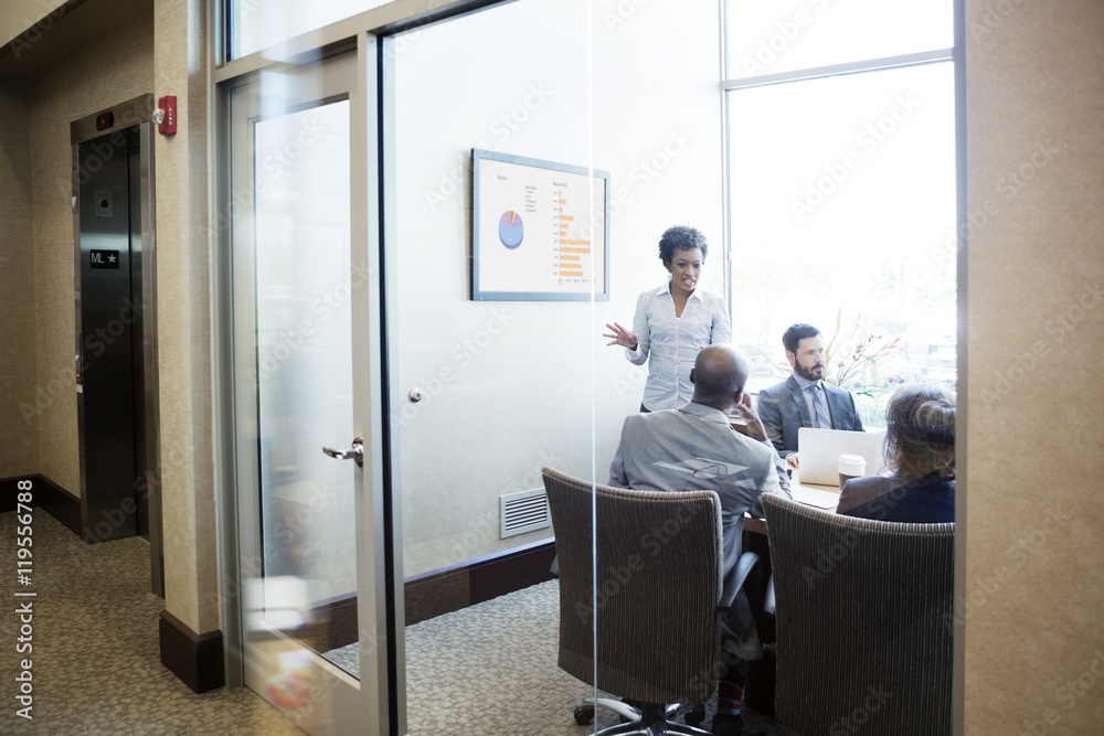 Businesswoman explaining colleagues during meeting in conference room Businesswoman explaining colleagues during meeting in conference room