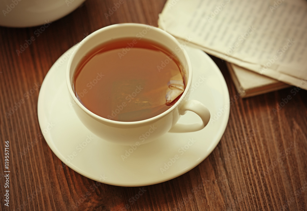 Cup of tea with newspaper on table Cup of tea with newspaper on table