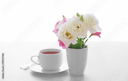 Cup of tea with flowers on table