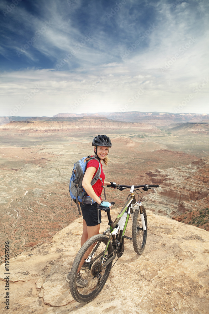 Portrait of woman standing with bicycle on cliff Portrait of woman standing with bicycle on cliff