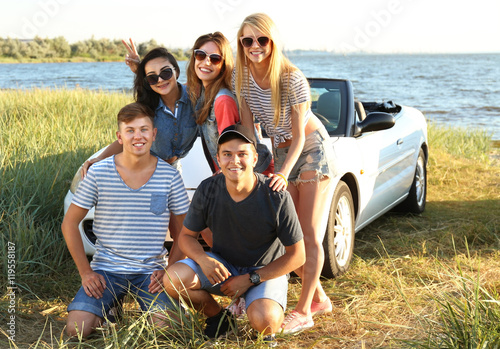 Happy friends near car