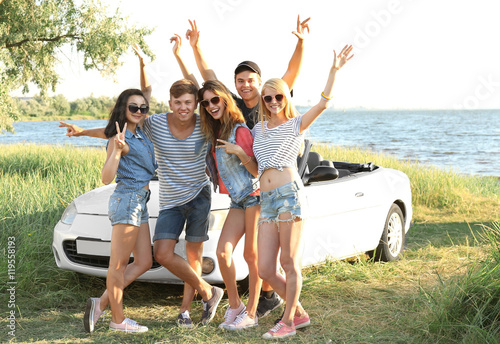 Happy friends near car