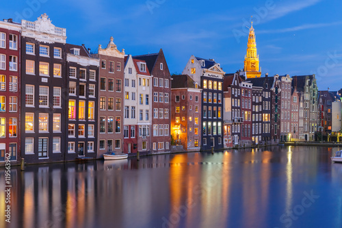 Amsterdam canal with typical houses and church during twilight blue hour, Holland, Netherlands