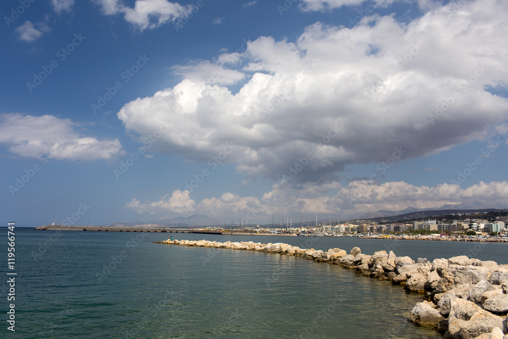 Stone pier stretching into the sea on the background of the old