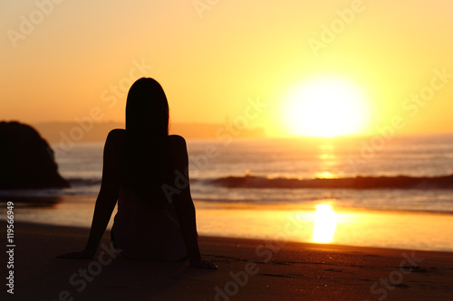 Woman silhouette watching sun at sunset © Antonioguillem