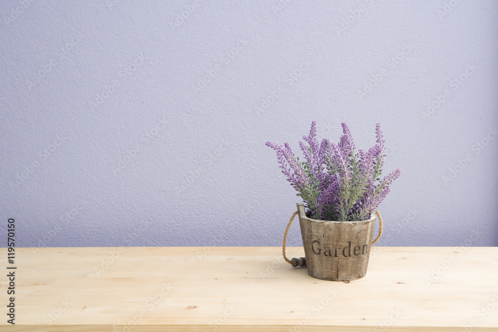 Fototapeta premium Wood table with purple lavender flower on flower pot and purple