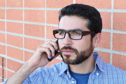 Closeup portrait upset, sad depressed worried confused man, student, son, father, worker talking on phone, isolated on brick wall background. 