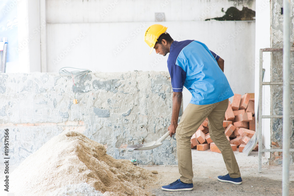 indian male contractor using shovel