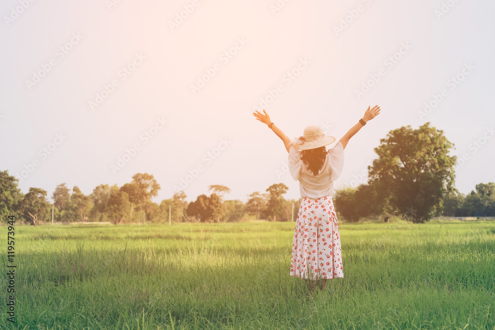 Woman breathing deep fresh air and outstretched arms in summer field at sunrise Woman breathing deep fresh air and outstretched arms in summer field at sunrise