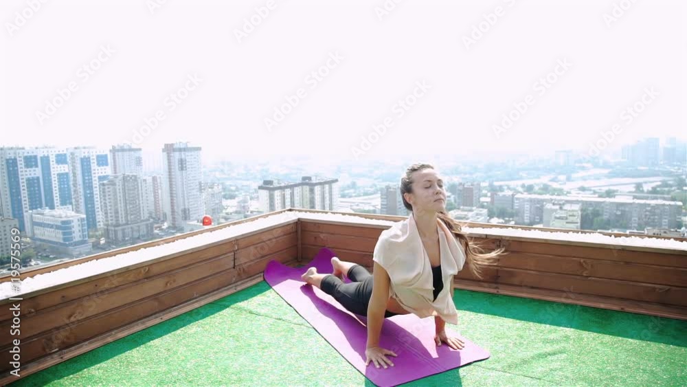 Yoga and meditation in a modern city. Young woman doing yoga on the roof. 20s. 1080p Slow Motion. Yoga and meditation in a modern city. Young woman doing yoga on the roof. 20s. 1080p Slow Motion.