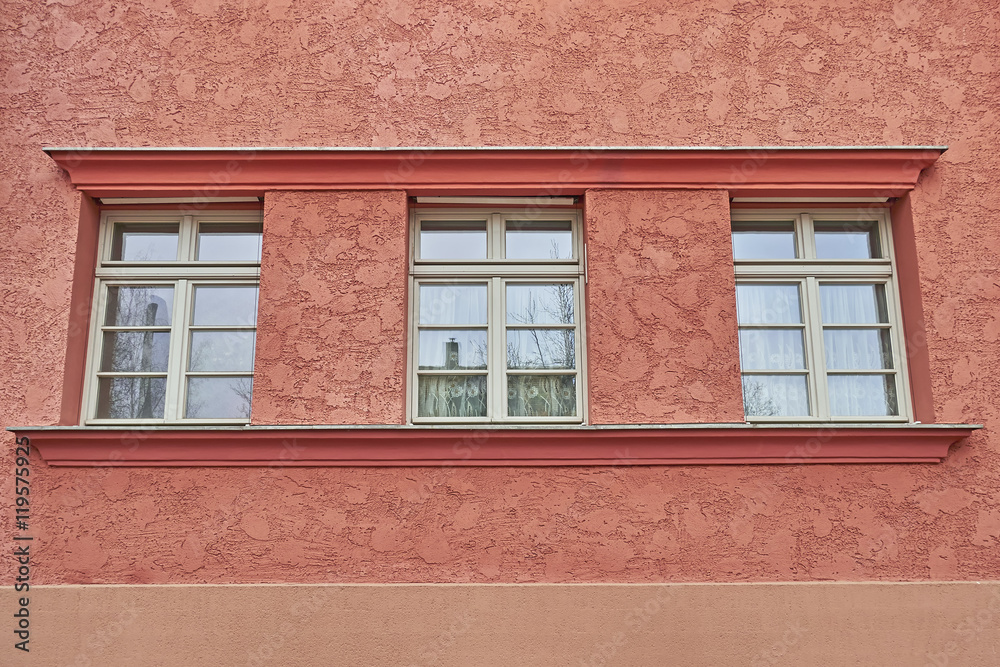 three windows row on colorful house wall