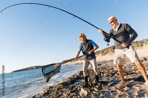 Senior man fishing with his grandson