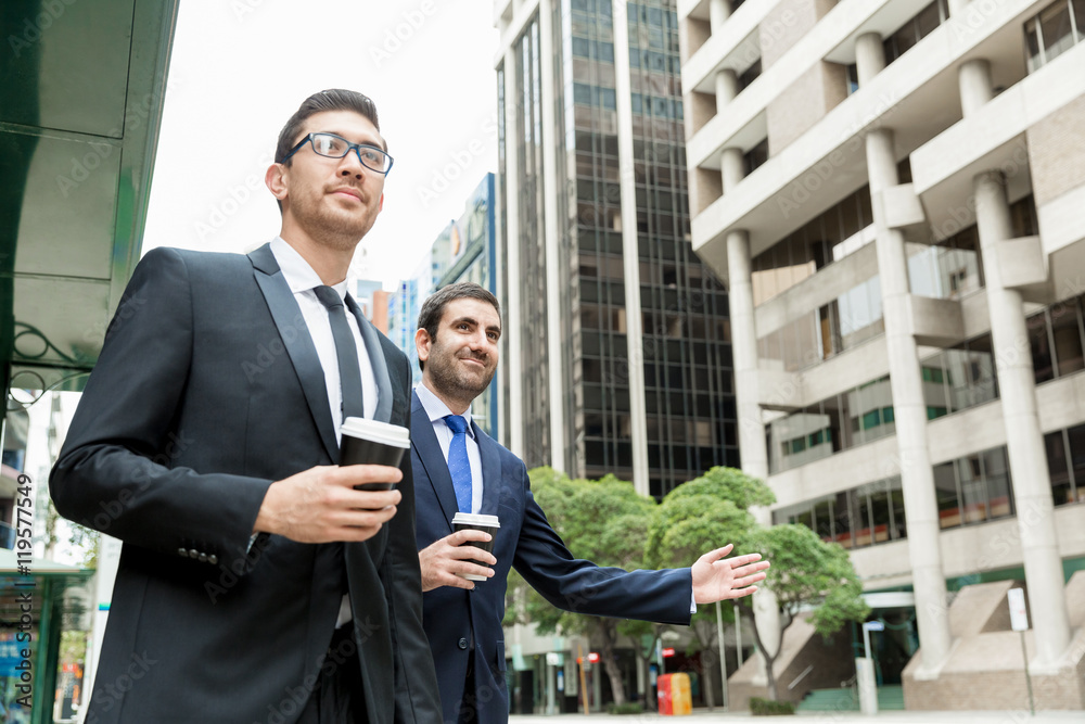 Two young businessmen hailing for a taxi Two young businessmen hailing for a taxi