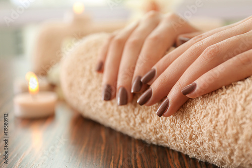 Fototapeta Naklejka Na Ścianę i Meble -  Female brown manicure on towel, closeup