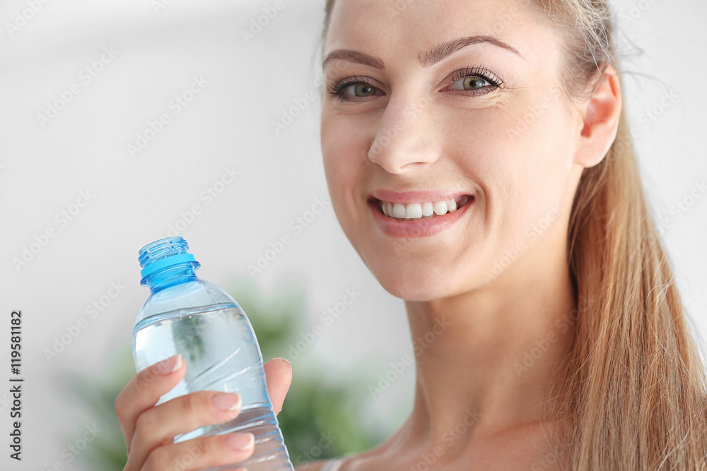 Beautiful girl drinking water on light background Beautiful girl drinking water on light background