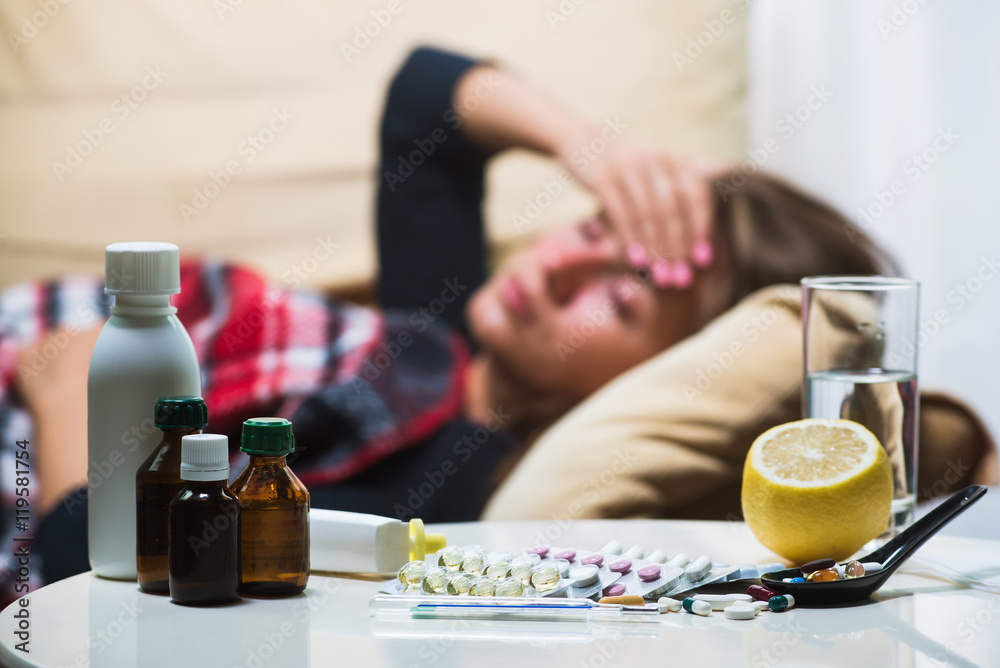 Sick woman lying on sofa under wool blanket Sick woman lying on sofa under wool blanket