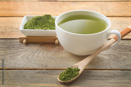 Cup of matcha tea on wooden background
