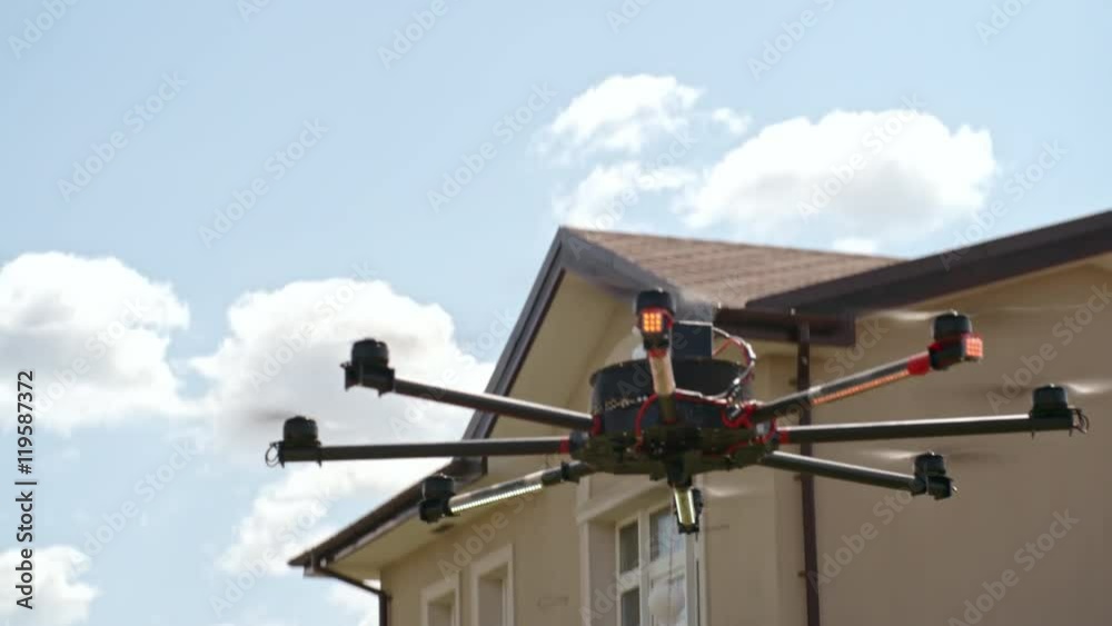 Drone carrying two pizza boxes and landing on the green lawn where excited man and woman waiting for delivery of food