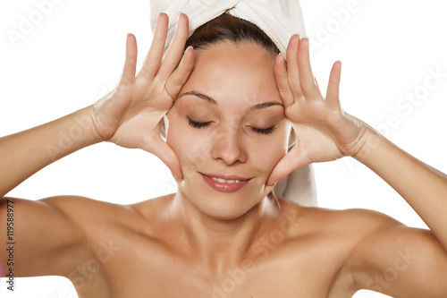 Fotografie young beautiful woman tightens her face with her hands.