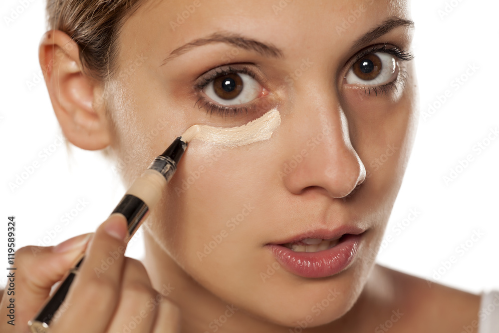 young beautiful woman applied concealer under the eyes young beautiful woman applied concealer under the eyes