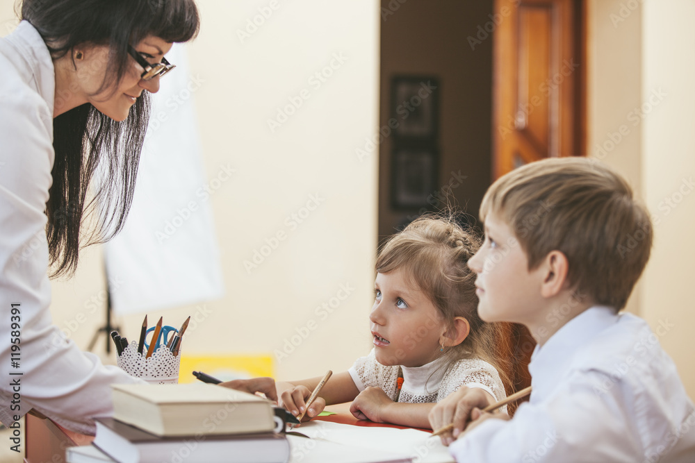 Boy and girl children with the teacher in the school Boy and girl children with the teacher in the school