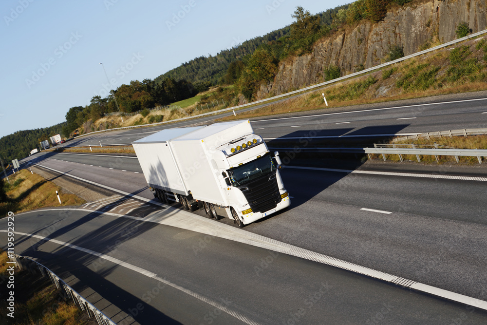 Naklejka premium large white truck driving on highway, elevated view