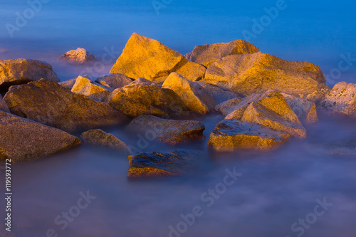 Sea rocks in mist at dusk