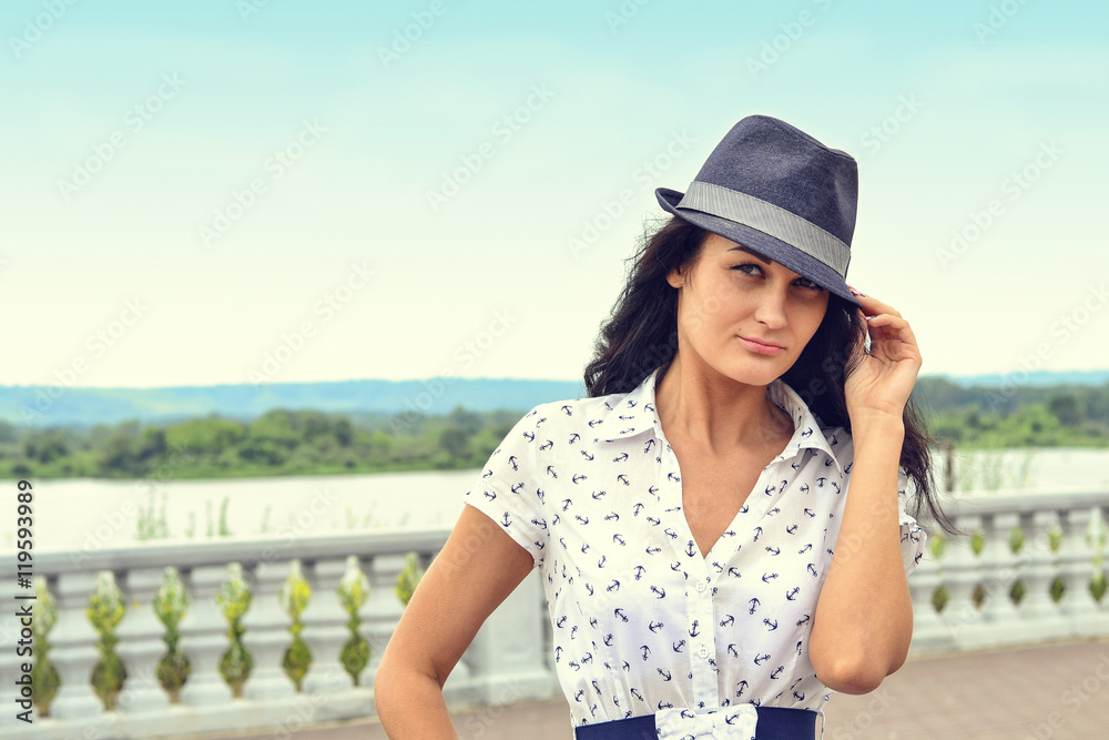 Portrait of beautiful girl in hat on the background of the sky a