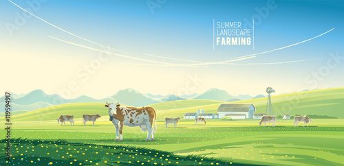 Rural landscape with cows and farm with mountain scenery in background.