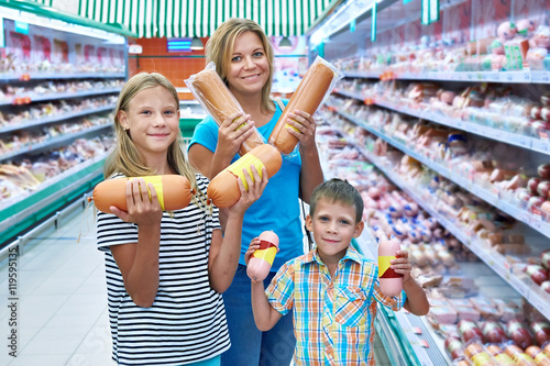 Family chooses sausages in shop photo