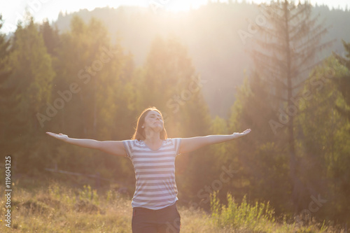 Beautiful girl meditating in the nature, at sunset