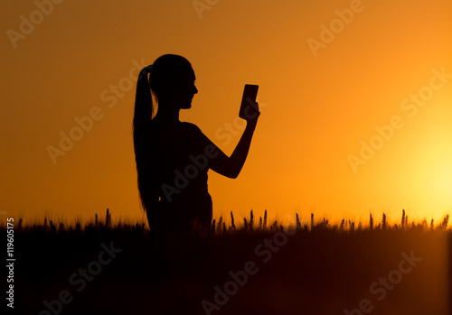 Silhouette of girl taking selfie