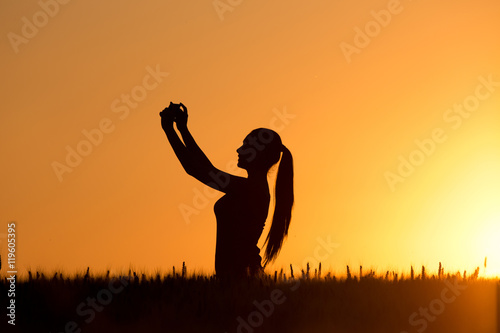 Silhouette of girl taking selfie