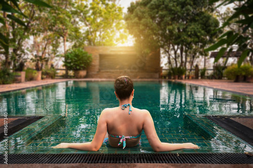 Woman sitting in swimming pool