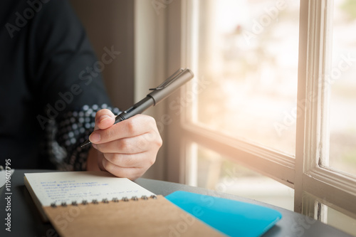Woman hand writing on notepad