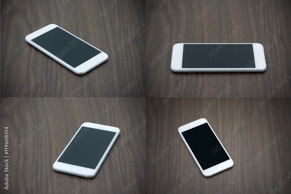 Smart phone in white color with blank screen on wooden table.