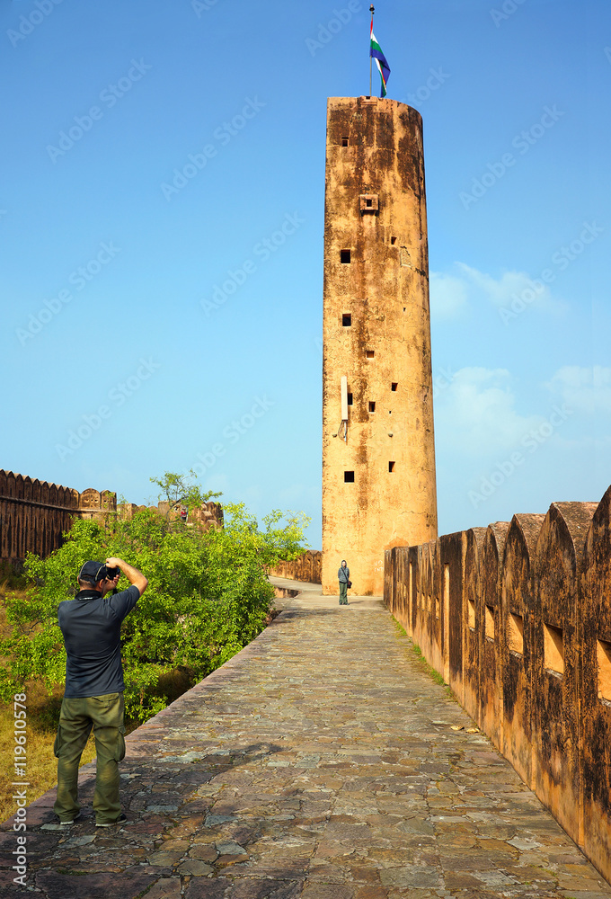 Φωτογραφία Unindentified tourist, white man, makes a photo of watch-tower on the wall at  Amber Fort in Jaipur city, Rajasthan, India
