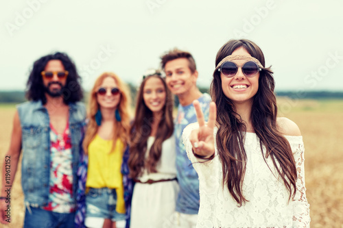 happy young hippie friends showing peace outdoors