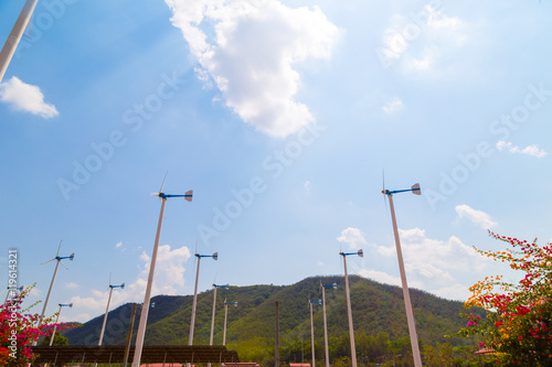 Wind turbine blue sky background agianst mountain