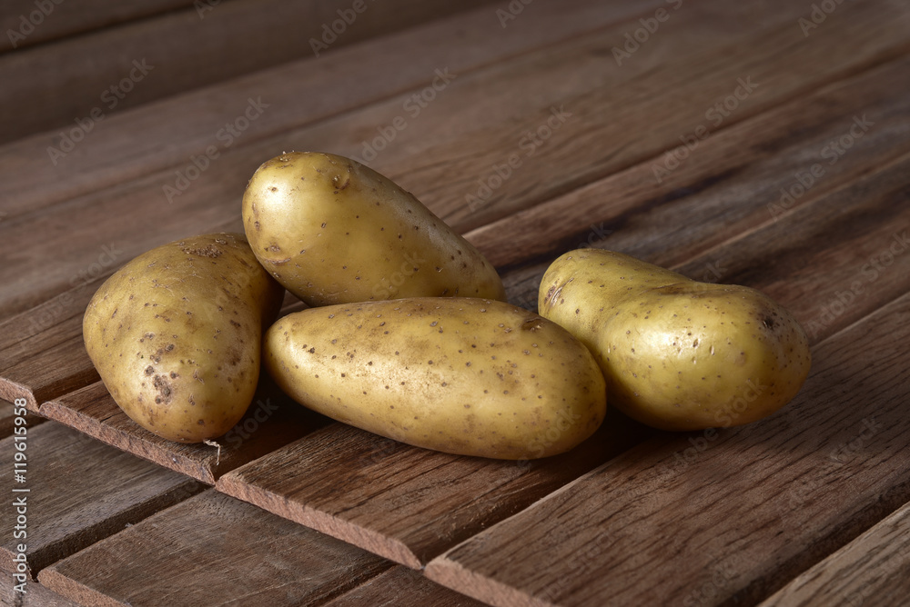 Fresh potatoes in an old sack on wooden background. Free place for text. Top view. Fresh potatoes in an old sack on wooden background. Free place for text. Top view.