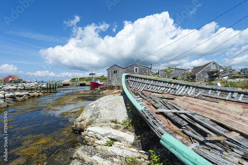 Dilapidated old fishing boat rests on the rocky shore of a fishing village in Peggy's Cove, in Halifax, Nova Scotia, Canada