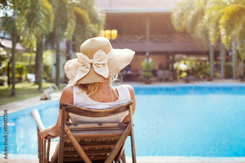 summer holidays in luxury hotel, woman relaxing near beautiful swimming pool