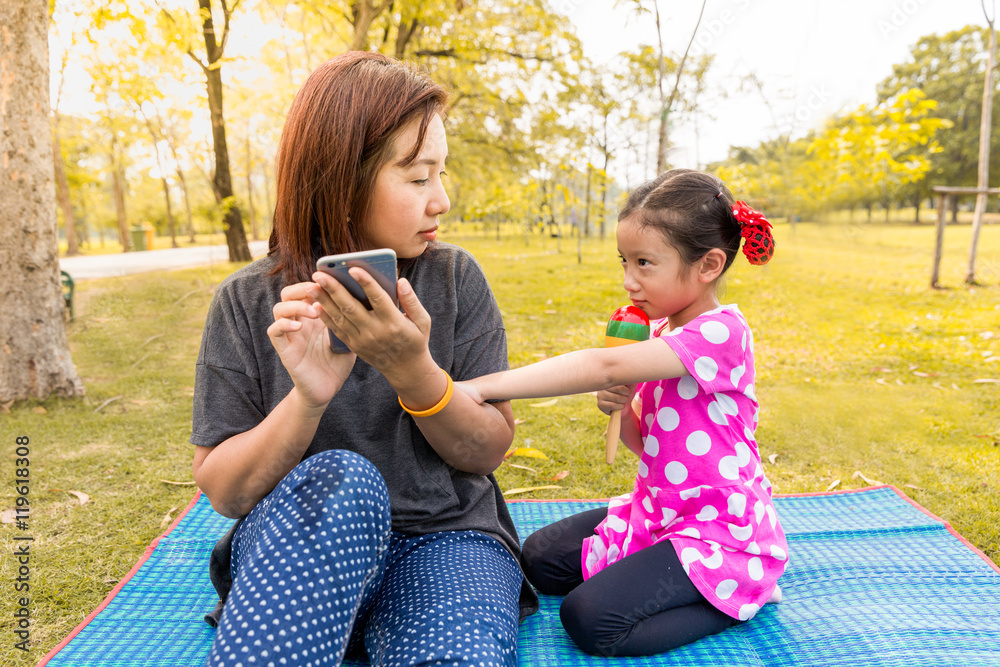 Mother playing smart phone with careless her daughter Mother playing smart phone with careless her daughter