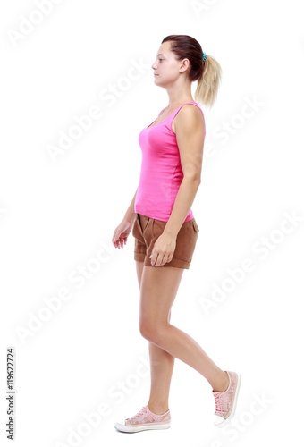 back view of walking woman. beautiful girl in motion. Isolated over white background. Sport blond in brown shorts out sideways.